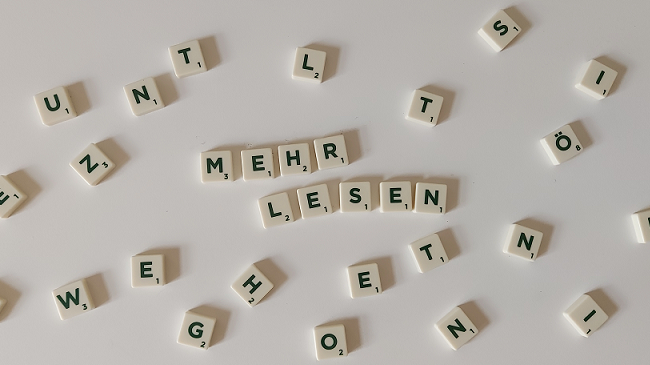 Schriftzug „Mehr Lesen“ aus Scrabble-Buchstaben auf einem weißen Untergrund.